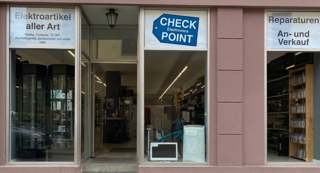 Ladenfront des Checkpoint in der Grabenstraße: drei Schaufenster, offene Glastür, blaues Schild Check Point Electronics.